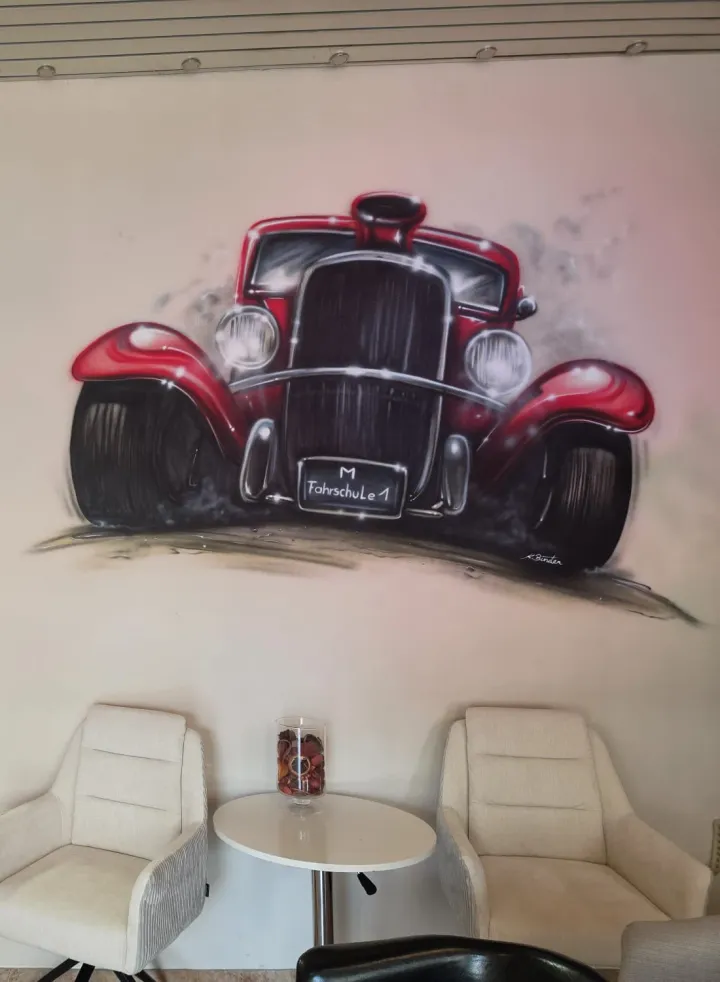 Wartebereich der Fahrschule Krampfl mit Wandbild eines roten Oldtimers